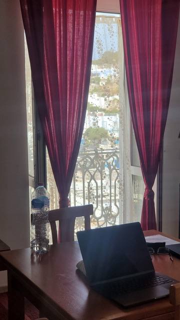 Finestra con tende rosse e vista sul porto