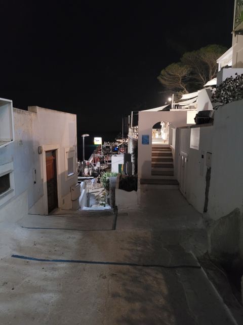 Il vicolo di Santa Maria di sera con l'arco d'ingresso della proprietà a destra e la discesa verso la spiaggia a sinistra
